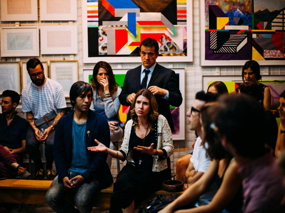 A member of an audience makes a point while gesturing.