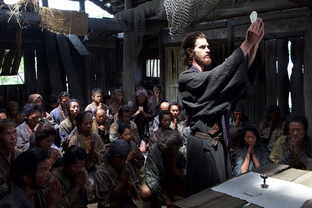 A 17th century monk holds up a wafer before an altar while Japanese Christians kneel.