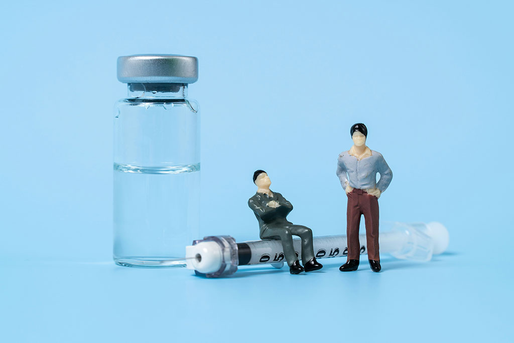 A tableau shows minature figures of two people, one sitting on a life size syringe and the other stands