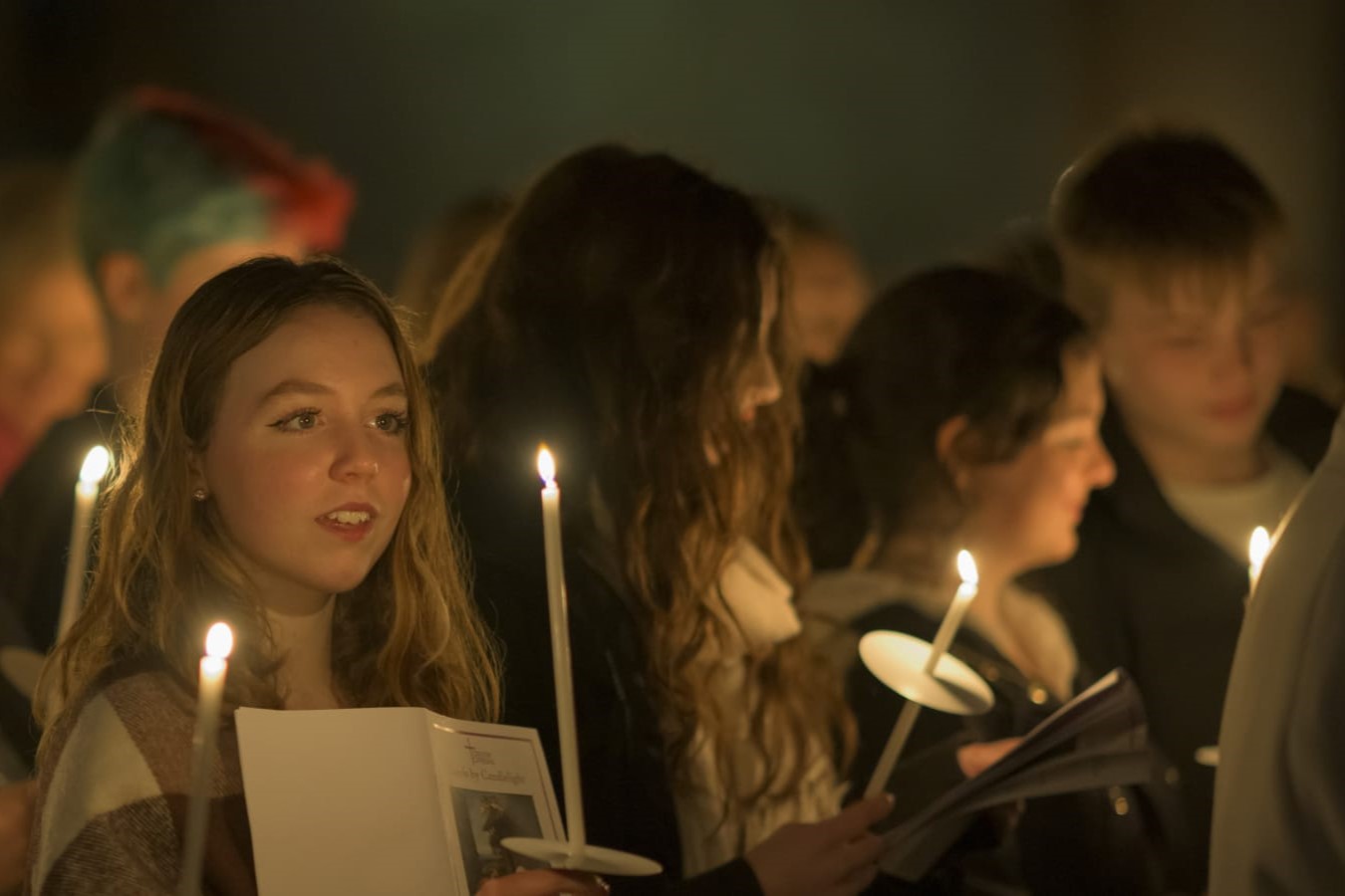 Carol singers, lit by candle light.