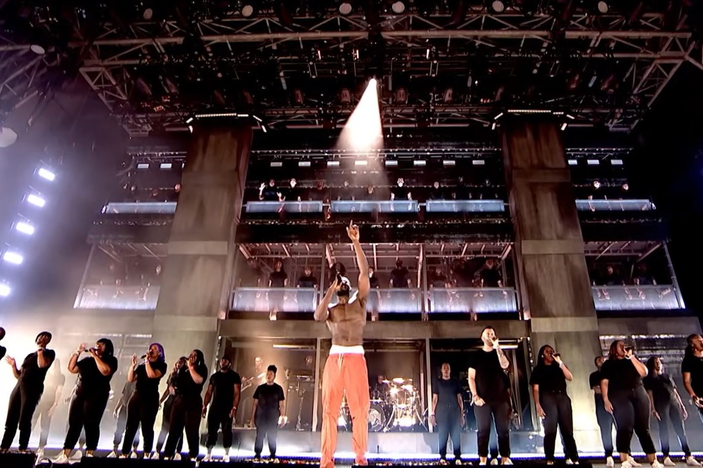 Rapper Stormzy raises a hand to heaven as he sings with a gospel choir on the Glastonbury stage.