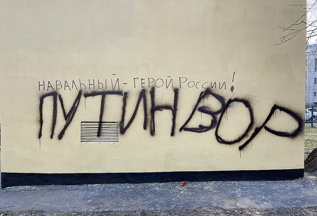 Graffiti on a wall, spells out in Russian character the name Navalny.