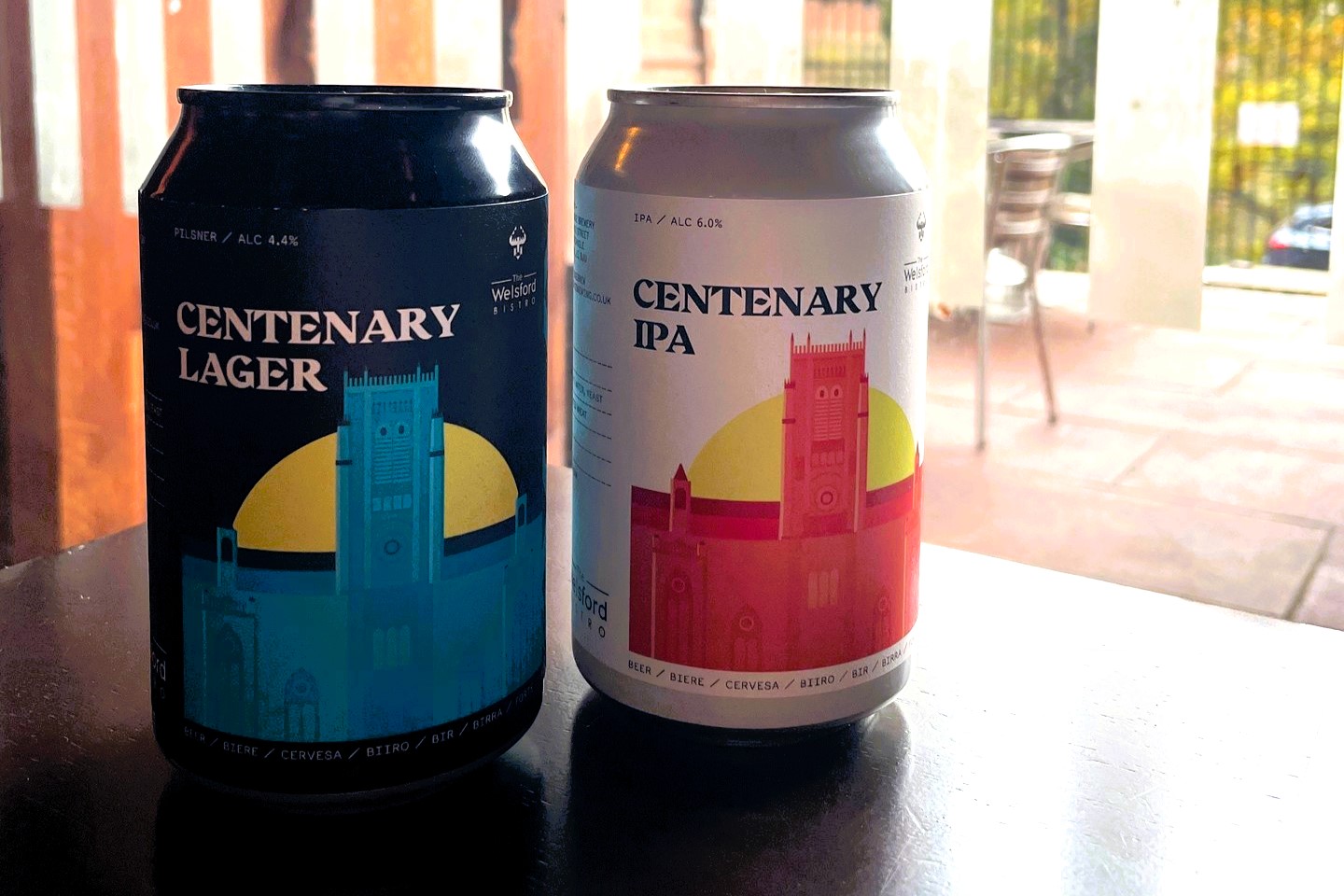 Two cans of beer depict a drawing of a cathedral.