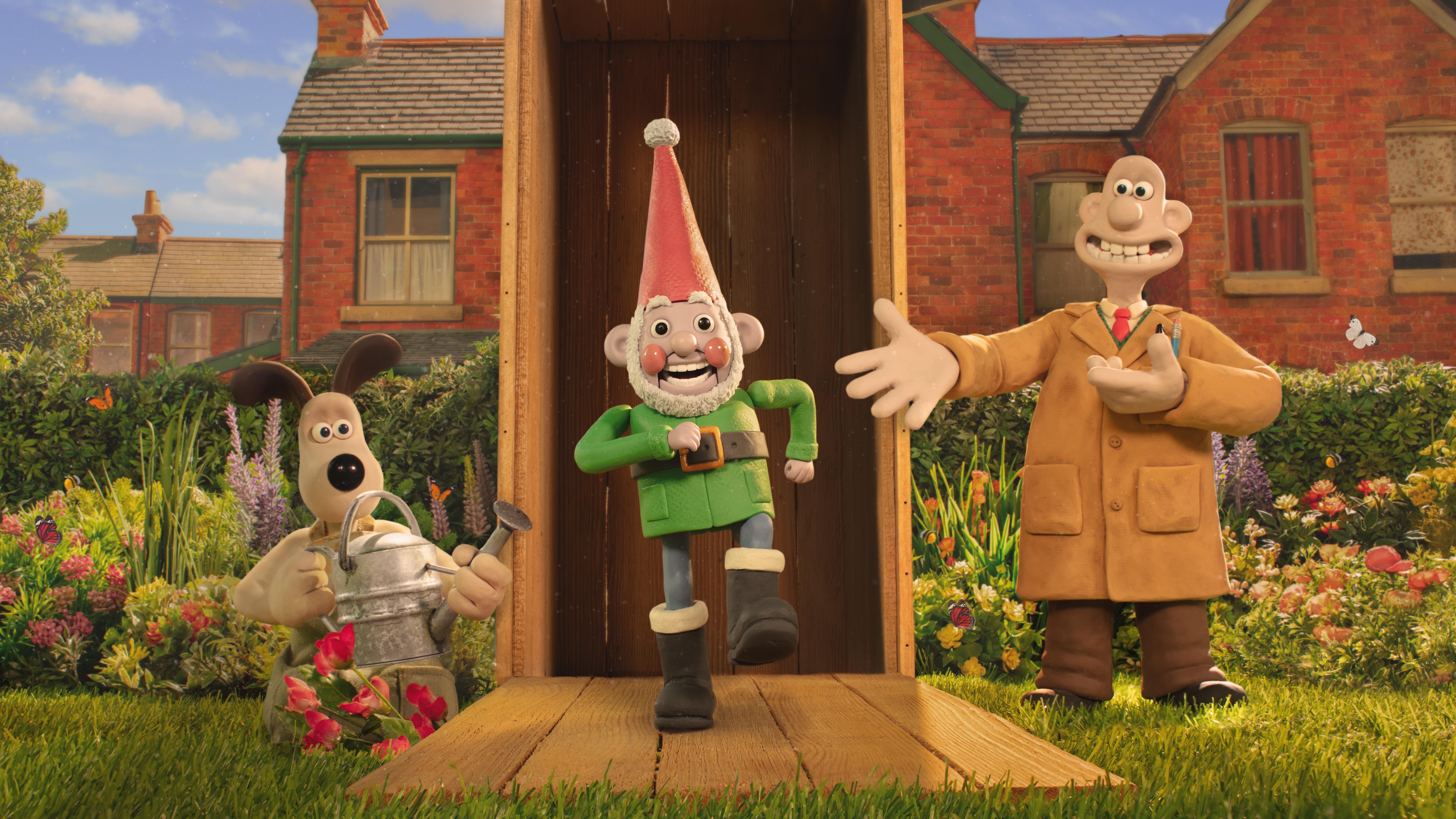 A still from a claymantion film shows three characters, Wallace, Gromit and a robot garden gnome marching out a garden shed.