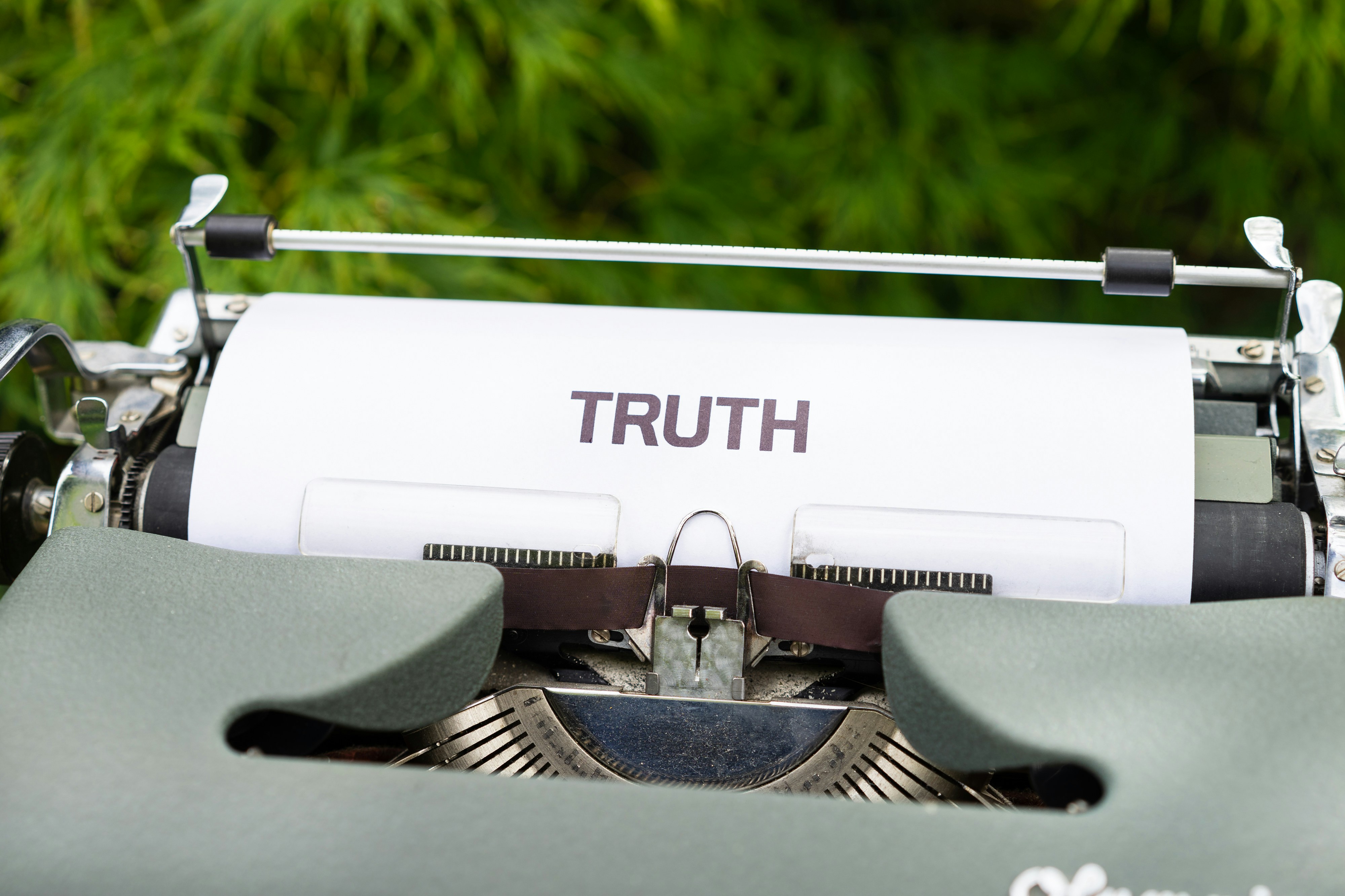 A typewriter holds a piece or paper reading 'truth'