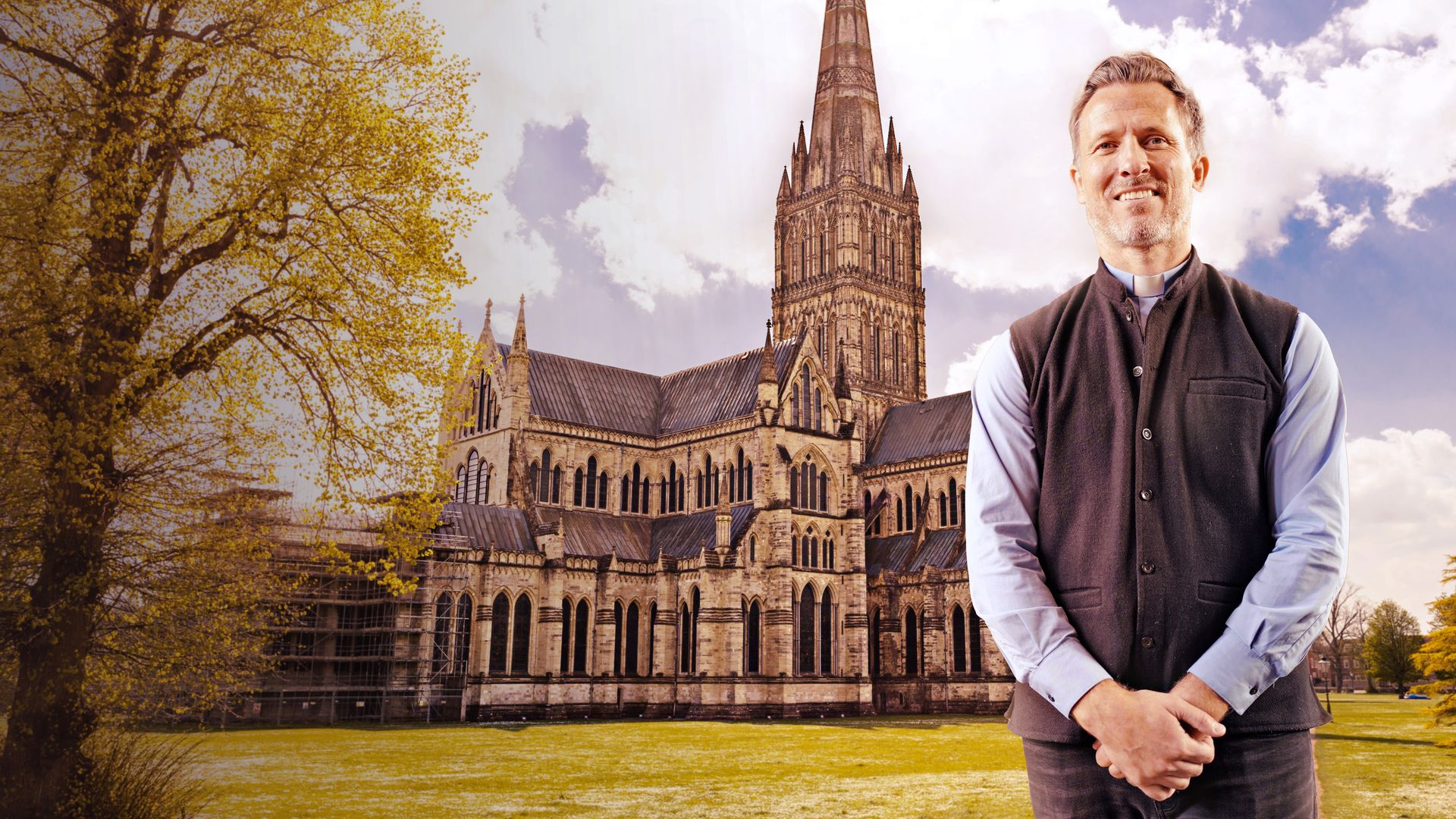 A vicar stands arms in front of himself, behind him is a cathedral