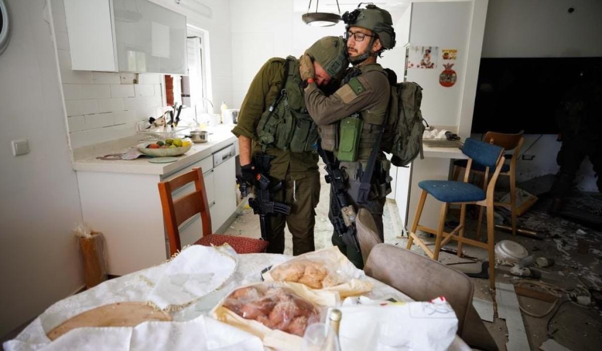 Two soliders console each other as they search a house that has been ransacked.