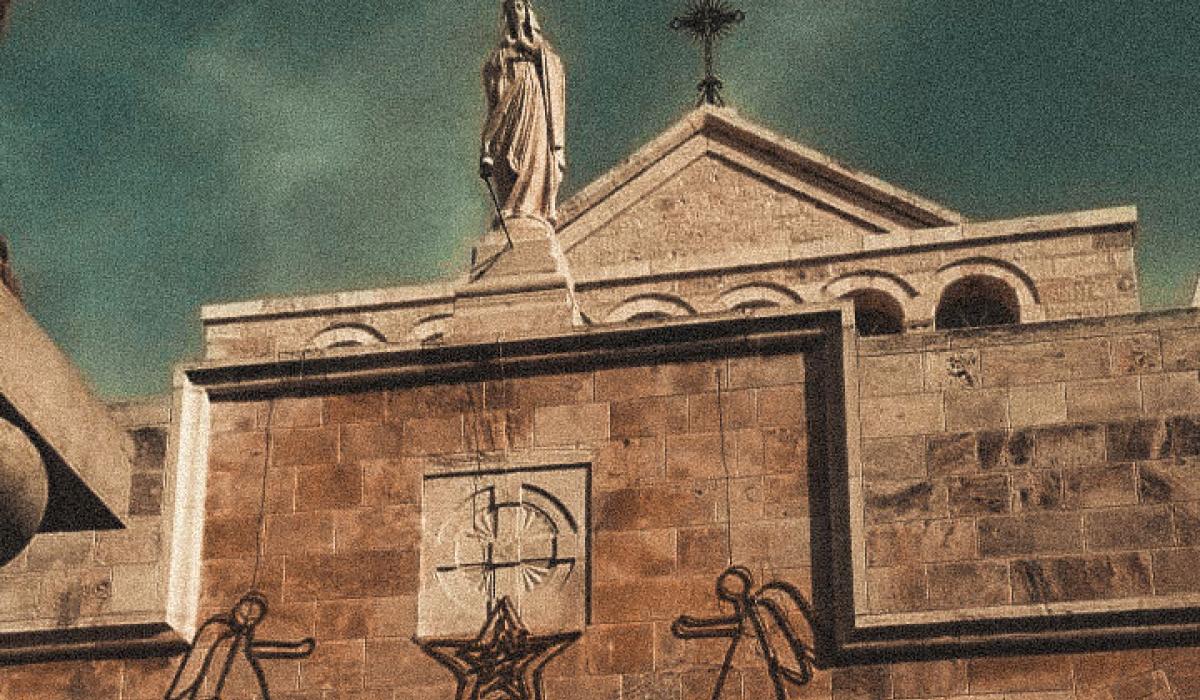 A church gable featuring a cross, a Madonna and angel Christmas decorations.