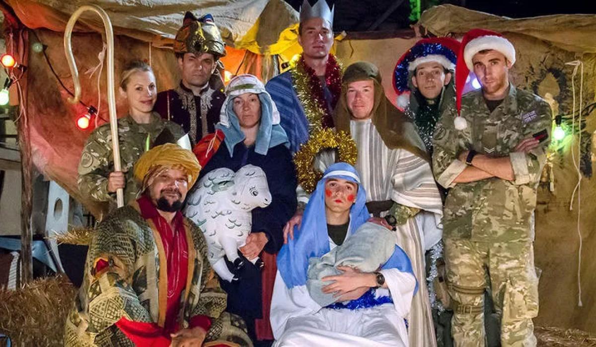 Dressed in camouflage uniforms and makeshift costumes, soldiers create a nativity scene