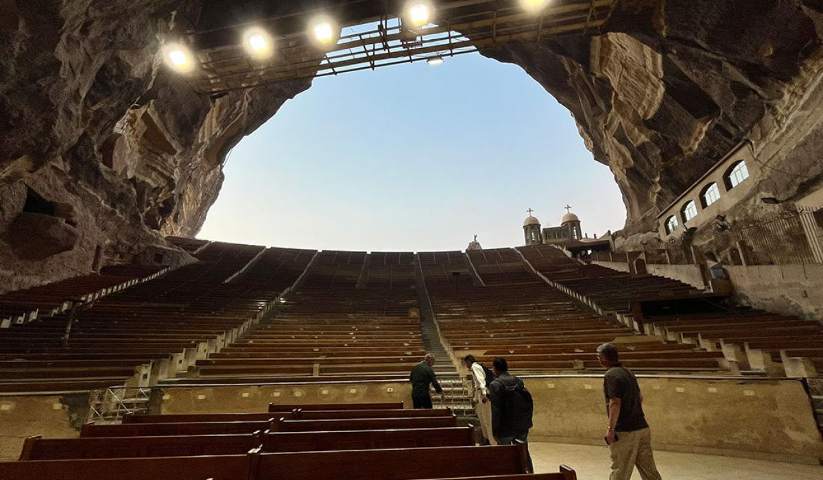 a view from the bottom of a huge cave to the sky, up row upon row of seating tiers.