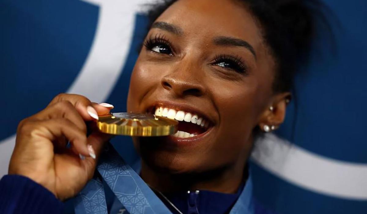 A gold medallist bites her medal.