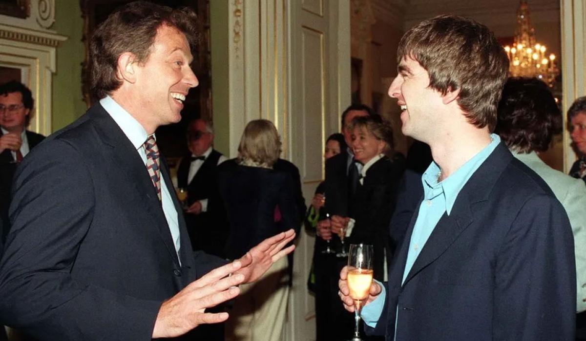 Tony Blair talks to a member of Oasis at a reception.