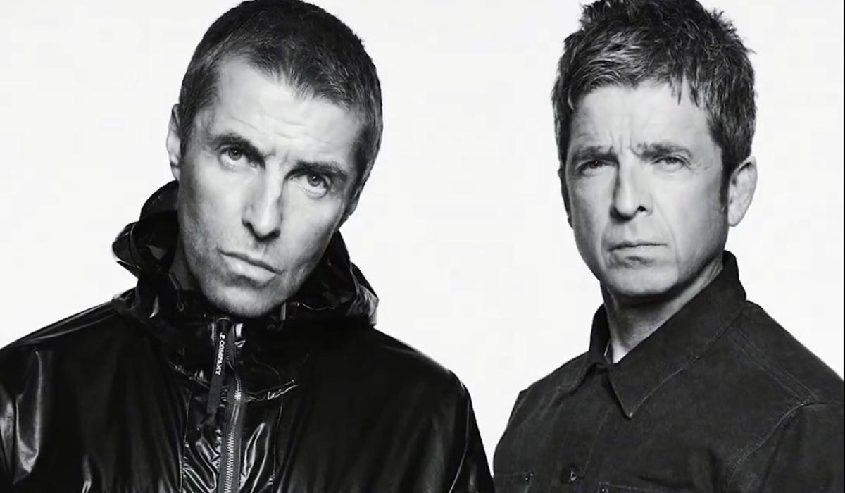 Two middle age rock star brothers pose for the camera in a black and white picture