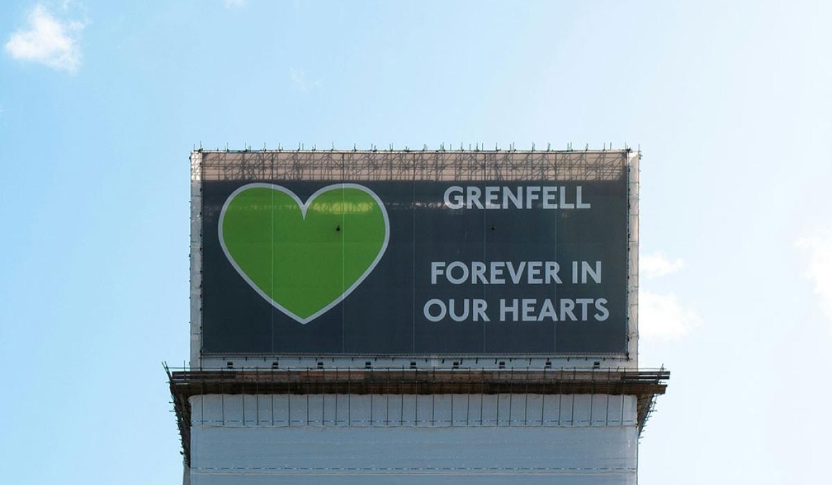 A wrapping around the Grenfell Tower bears a giant green heart.