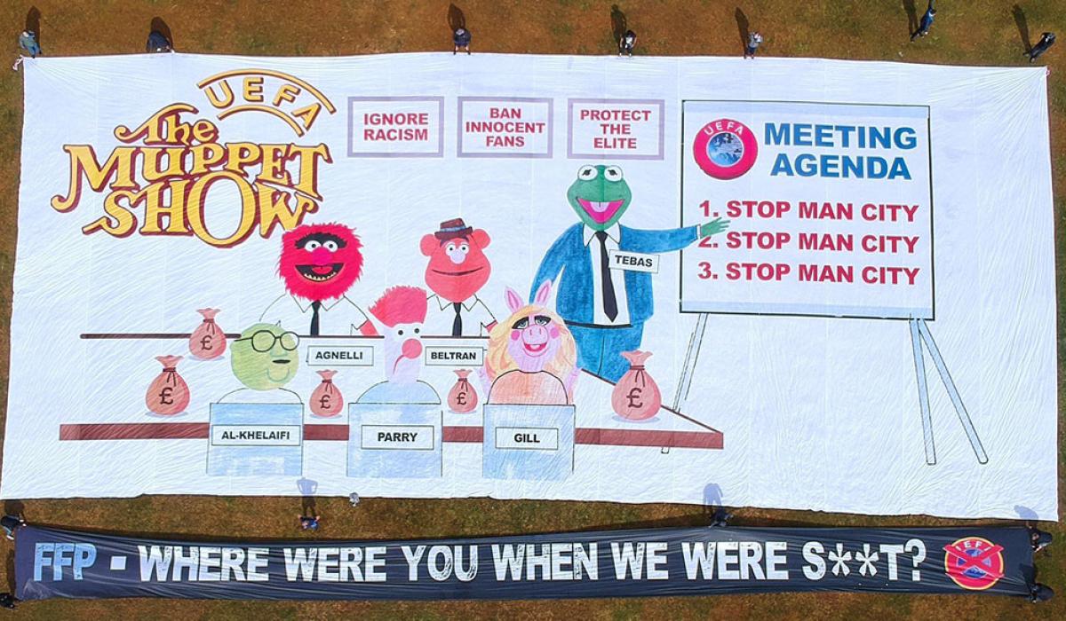 A football support protest banner depicts The Muppet Show logo, a meeting of men in suits and various slogans.