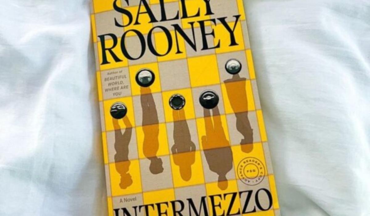 A book cover depicts a yellow and white chessboard with pieces casting shadows of people.