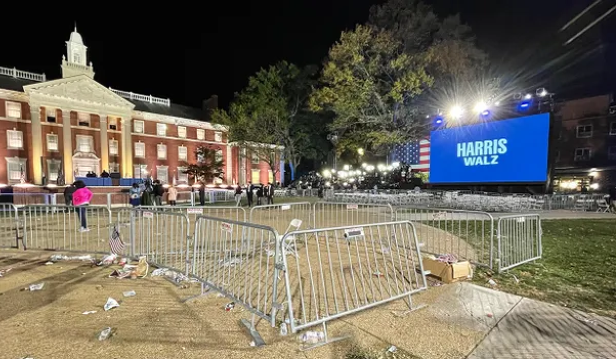 Crowd barrier surround empty space at a night time political rally.