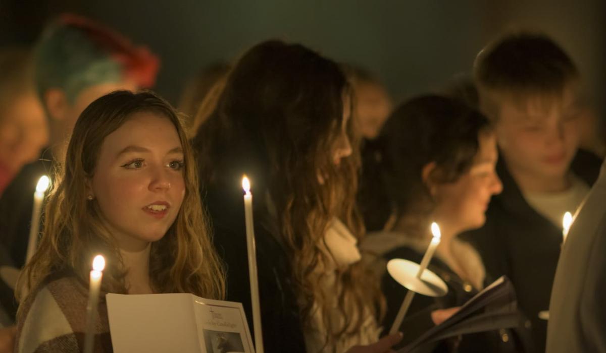 Carol singers, lit by candle light.