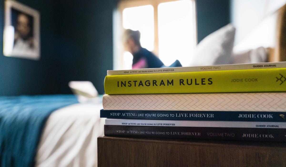 A pile of books on a bedside table.