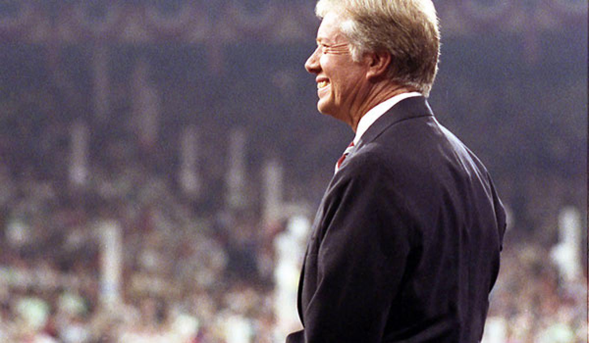 Jimmy Cater stands on a convention stage looking out over the crowd.