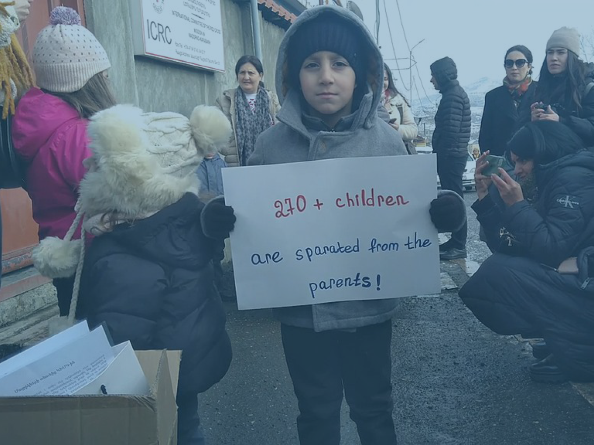 A child protestor holds a placard at a demonstration