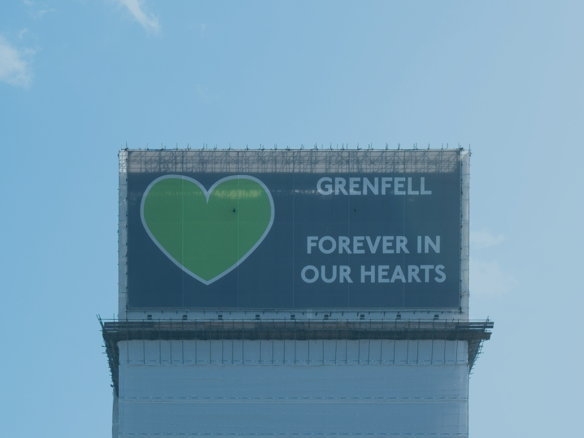 Grenfell Tower, wrapped in a protective layer bearing the legend: Grenfell forever in our hearts