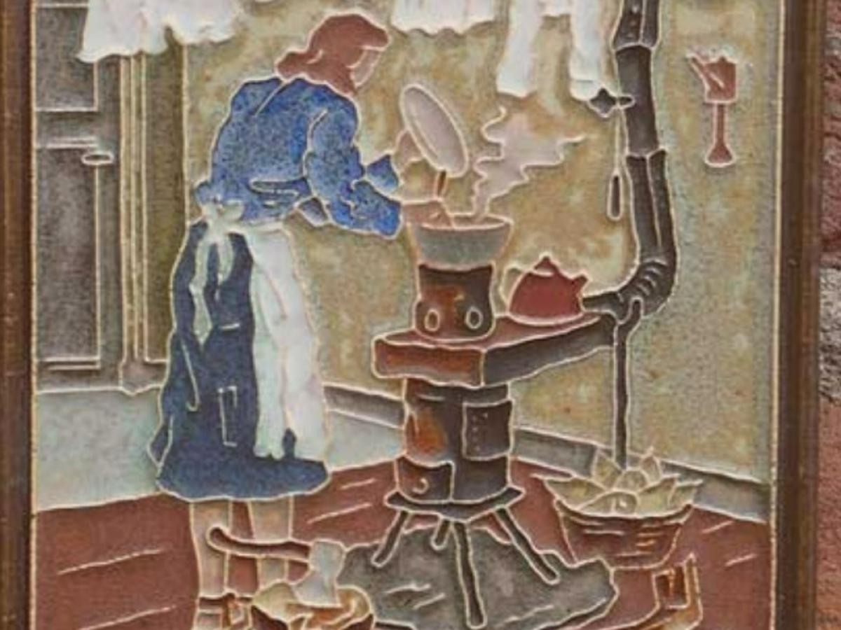 A wall tile shows a 1940s woman tend a stove below a washing line.