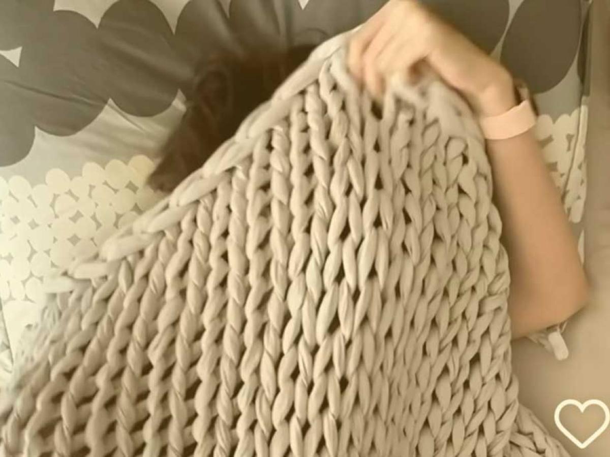 a sleeper pulls a blanket up over their head.