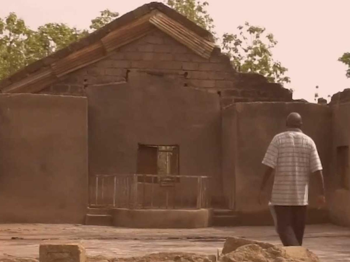 A person stands in the burn out shell of a church in Nigeria.