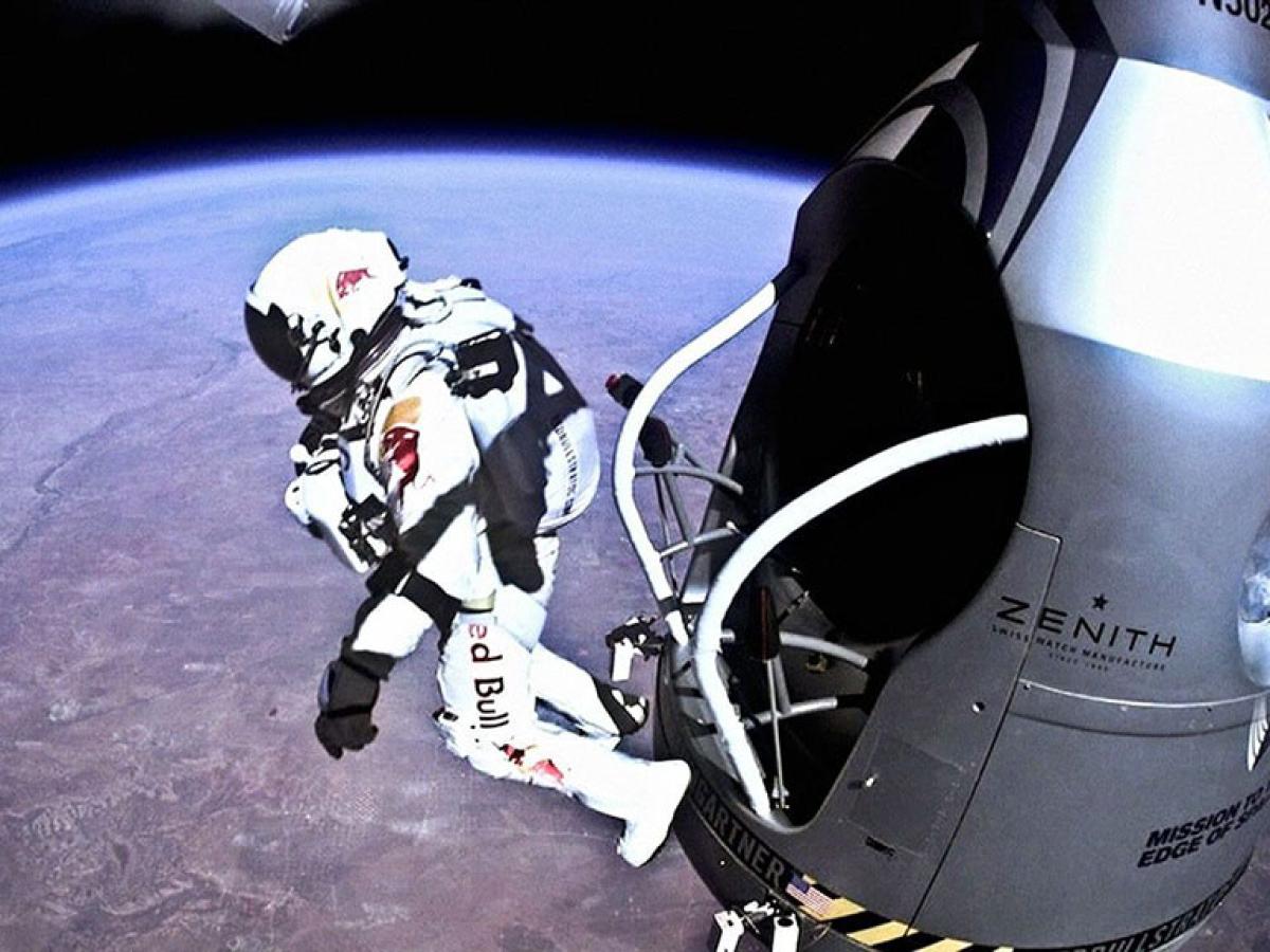 A skydiver in a space pressure shoot leaps from a capsule above the earth.