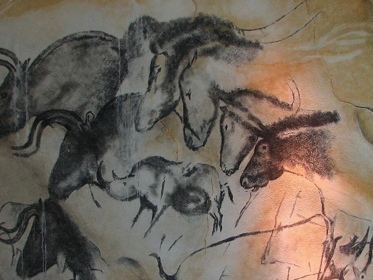 A cave wall drawing of wild animals galloping across other images of themselves.