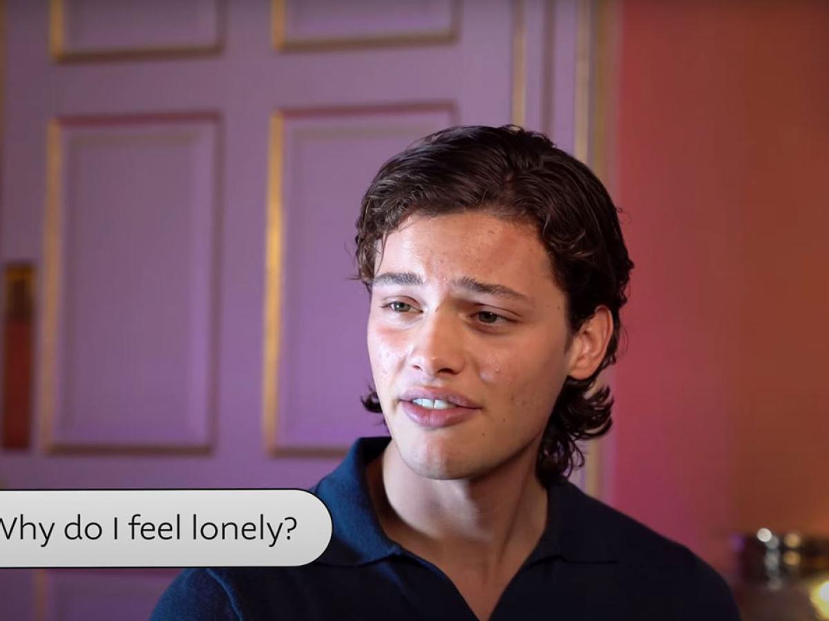 a young man looks pensive as he answers a questuon while sitting in a fancy room.