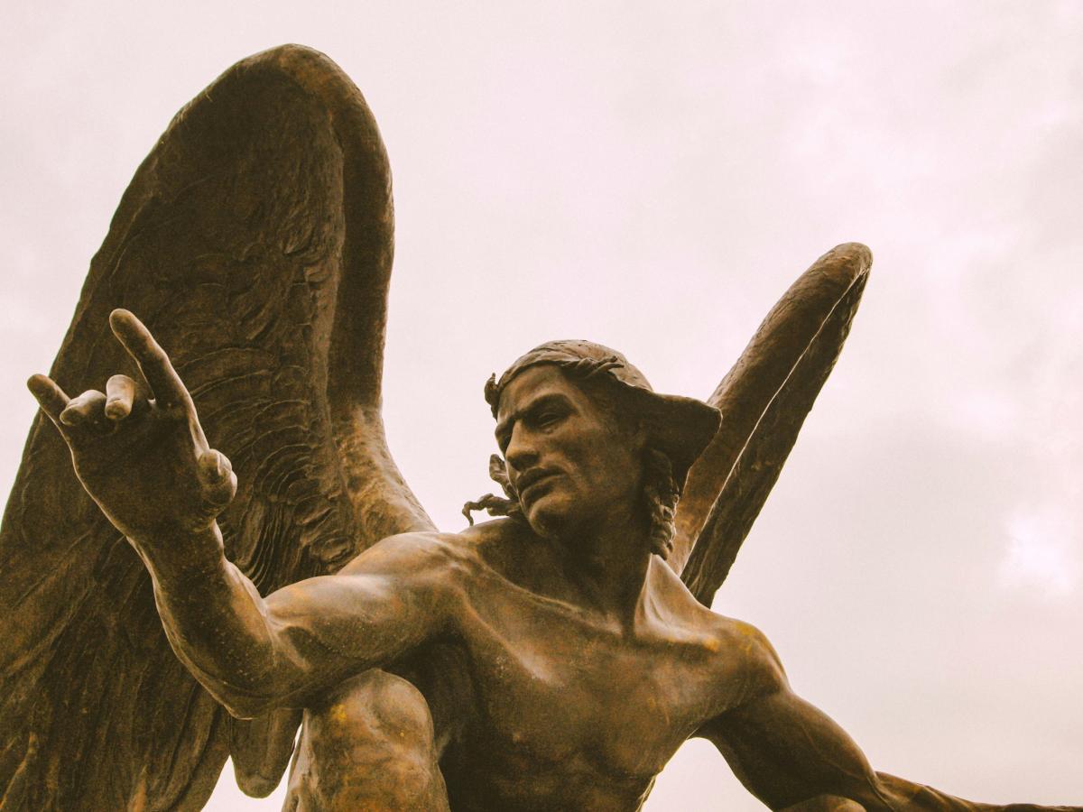 A statue of an angel crouching and gesturing with one hand.