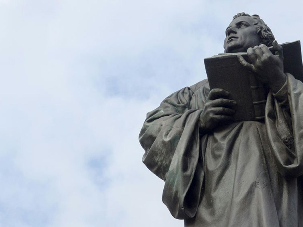 Looking up at a statue of Martin Luther holding an open bible.