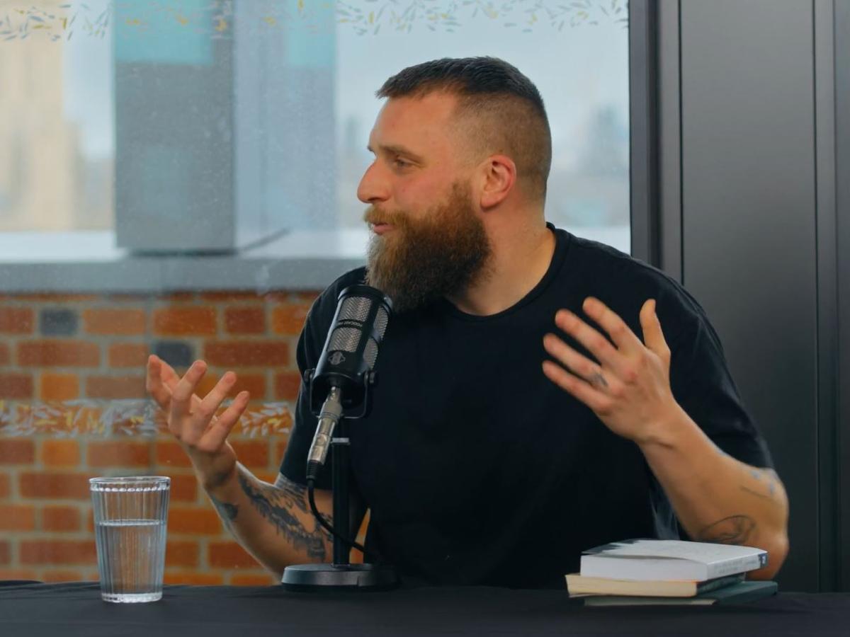 A guest on a podcast, gesture in front of a microphone.