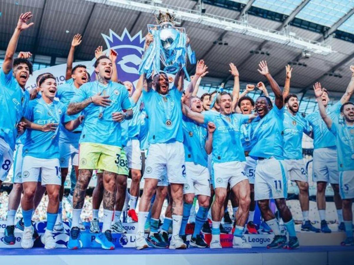 A football team wearing a sky blue kit leaps for joy holding a trophy.