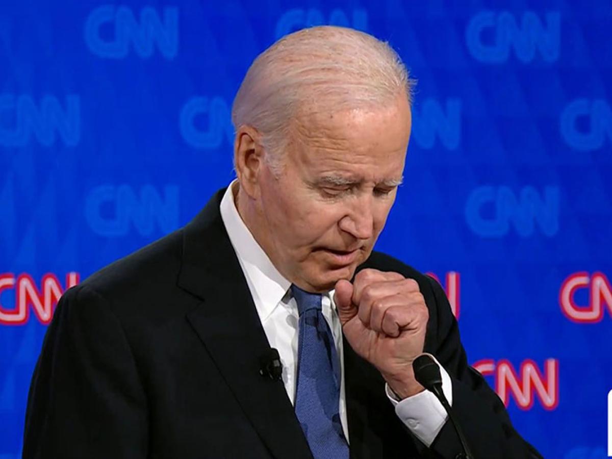 Joe Biden holds a fist to his chest as he stands and speaks.