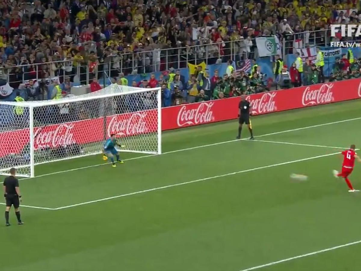 A footballer takes a penalty kick.