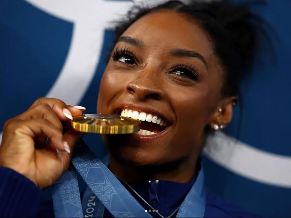 A gold medallist bites her medal.