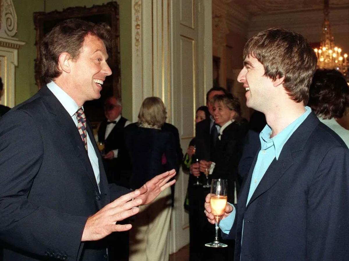 Tony Blair talks to a member of Oasis at a reception.