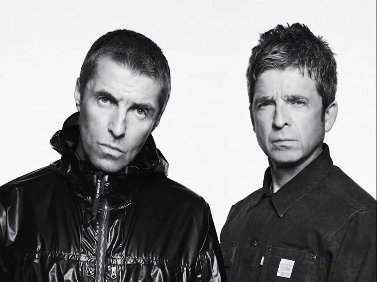 Two middle age rock star brothers pose for the camera in a black and white picture