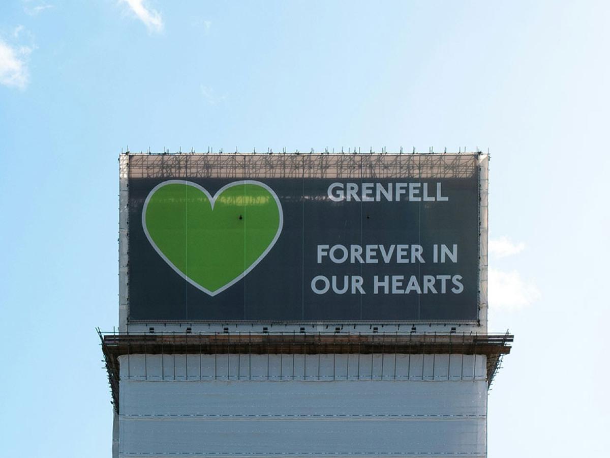 A wrapping around the Grenfell Tower bears a giant green heart.