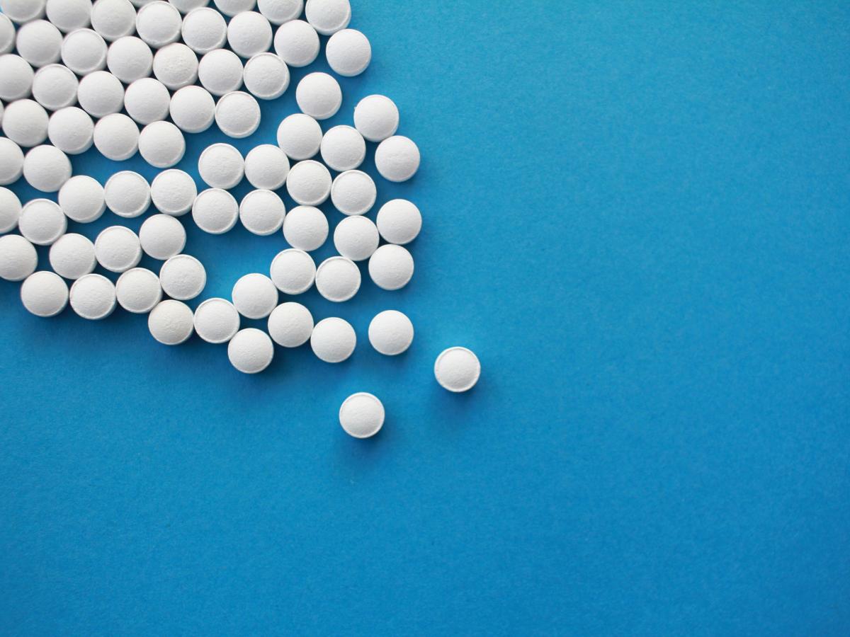 white pills form an angle on a blue background