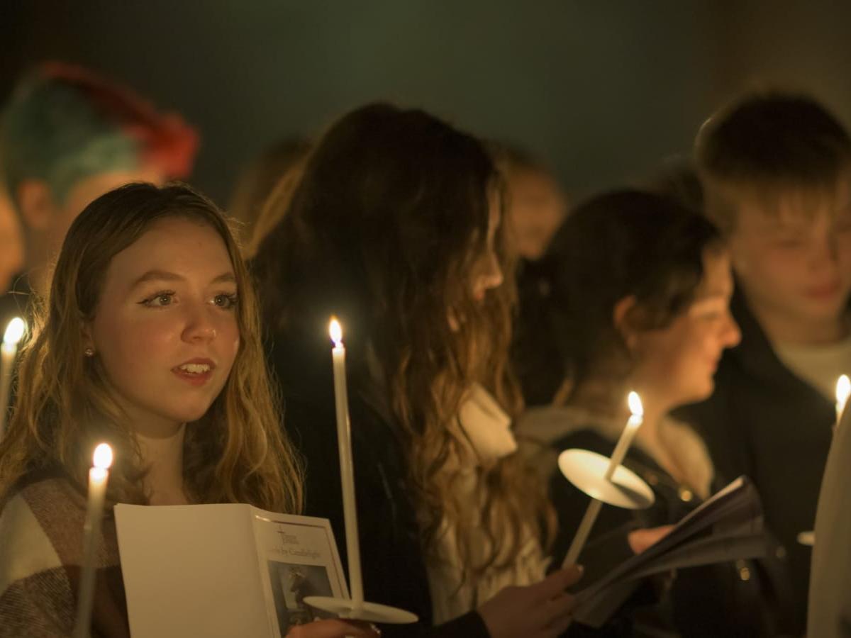 Carol singers, lit by candle light.