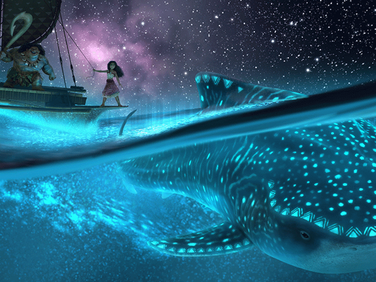 A cartoon still shows a nightscape at sea with a Polynesian style vessel above, with Moana standing on it sailing above a whale illuminated by bioluminescence 