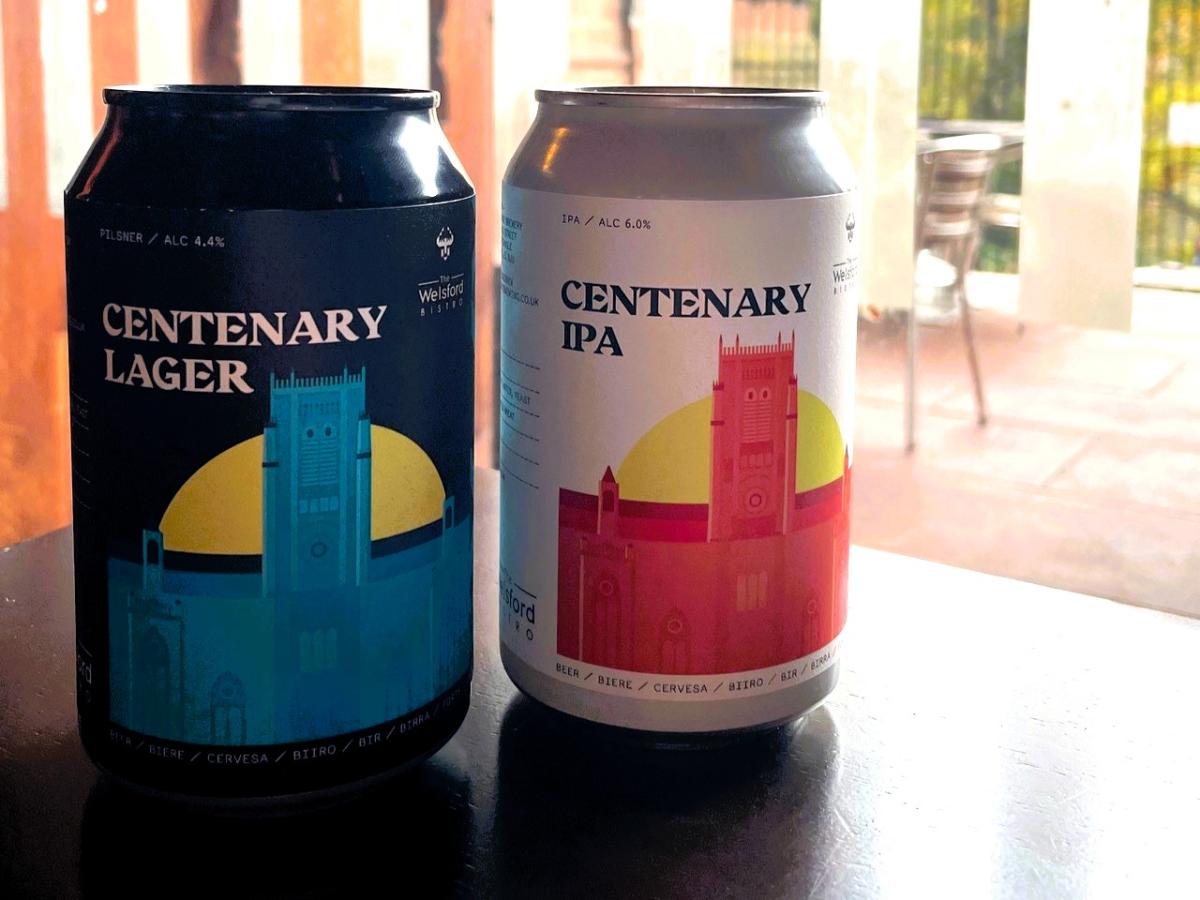 Two cans of beer depict a drawing of a cathedral.