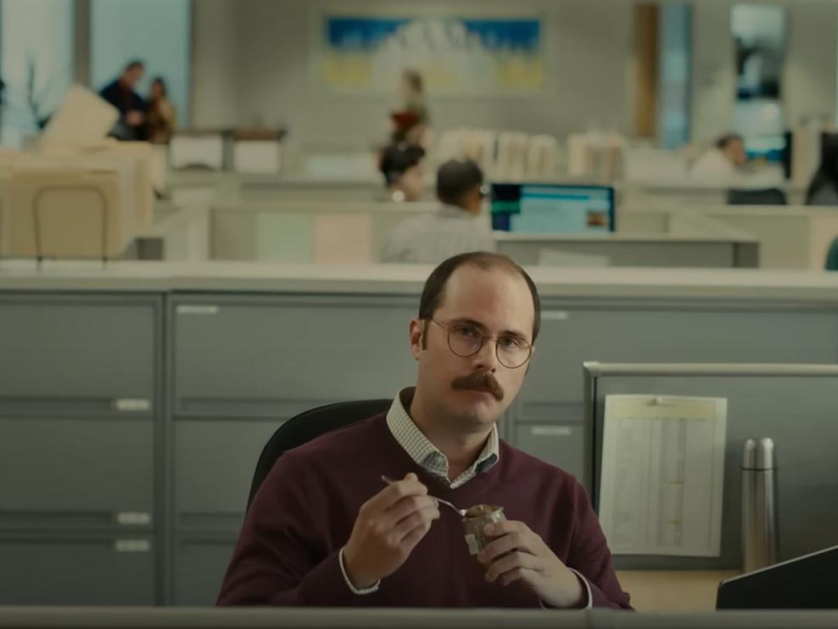 A worker at a desk sits back contemplating a situation