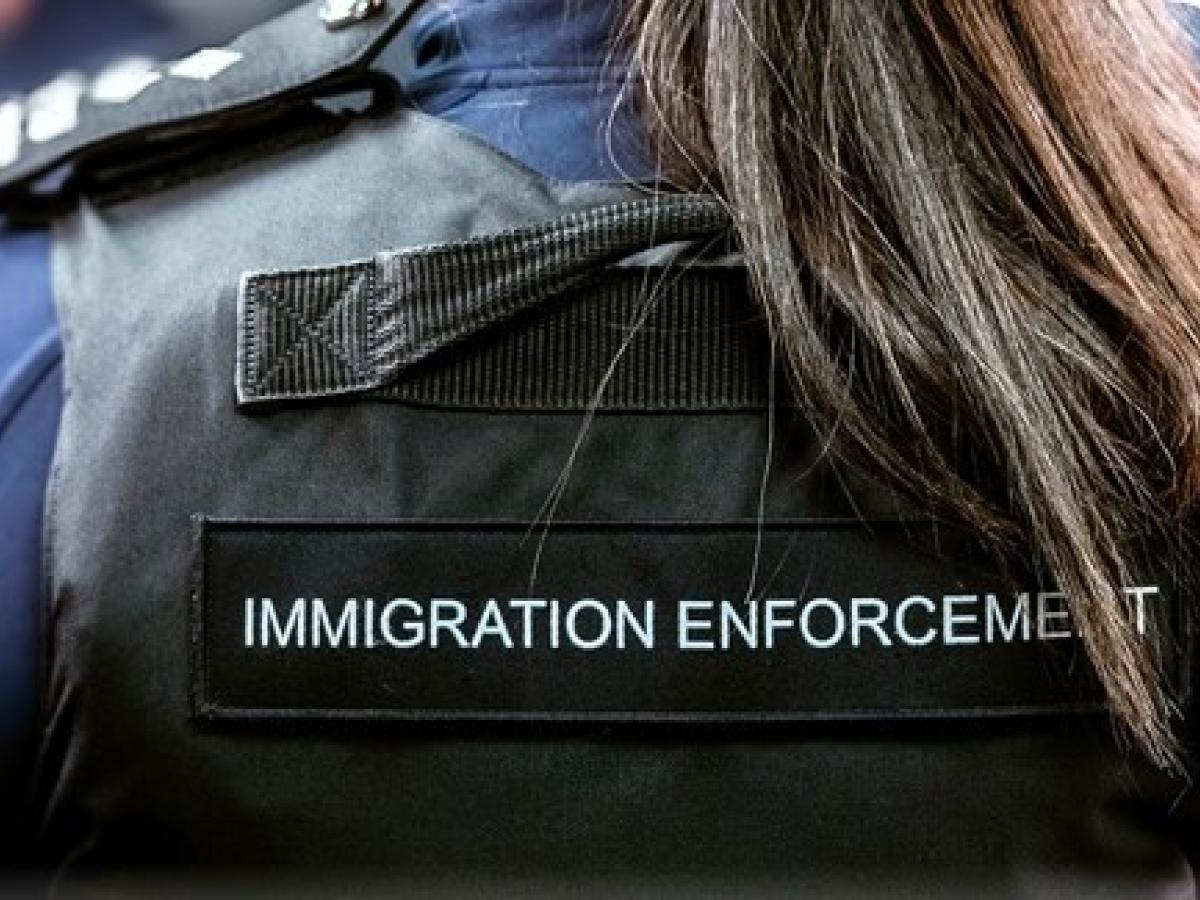 A Border Force officer wears body armour with Immigration Enforcement written on the back