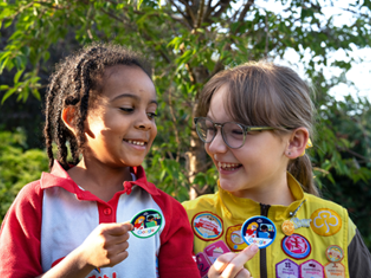 Two Brownies point out their badges.