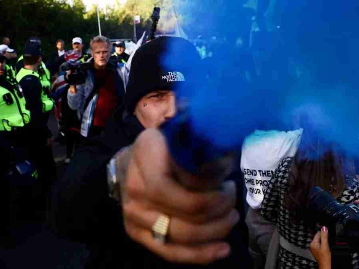 A protester hold a blue flare towards the camera